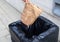 Closeup hand throwing a crumpled paper bag in the trash