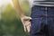 Closeup hand of woman us finger putting in back jean pocket for relax live in park background