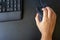 Closeup on the hand of a woman using her computer, with a keyboard and a mouse