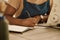 Closeup on hands of african american designer. Tailor writing in her notebook. Creative designer writing a list in a