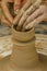 Closeup of the hands of the artist creating a clay pot, the trad