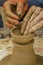 Closeup of the hands of the artist creating a clay pot, the trad