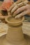 Closeup of the hands of the artist creating a clay pot, the trad