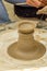 Closeup of the hands of the artist creating a clay pot, the trad