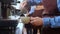 Closeup hands of barista preparing making coffee cappuccino or latte while pouring milk in coffee cup in cafe.