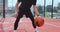 Closeup hands bouncing basketball ball. Man is practicing exersice hitting basketball ball training on court in city