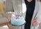 Closeup of hands carrying birthday cake with candle for baby`s f