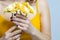 Closeup of Hands of Caucasian Female Holding Bouquet of Yellow Flowers