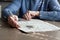 Closeup of hands of elderly woman, sitting at table in her home, solving crossword puzzle. Cognitive rehabilitation therapy for