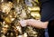Closeup of hands gilding gold leaf sheet to Buddha statue in Thai temple