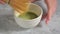 Closeup on hands of a girls blending with a bambu chasen in a white bowl some green tea matcha