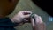 Closeup on hands of goldsmith working on a ring in his workshop