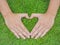 Closeup hands in the grass with the form of heart shape