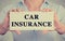 Closeup hands holding card sign car insurance text message