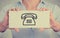 Closeup hands holding card sign with telephone contact icon