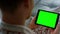 Closeup hands holding chroma key tablet. Unknown man typing green screen at home