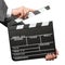 Closeup of hands holding movie clapper board