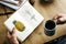 Closeup of hands holding open novel and coffee cup