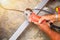 Closeup hands of laborer holding electric angle grinder working cutting aluminum