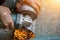 Closeup hands of laborer holding electric angle grinder working cutting galvanized pipe at construction site