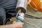 Closeup hands of laborer holding electric angle grinder working cutting galvanized pipe at construction site