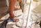 Closeup hands of laborer holding electric drill working drilling aluminum lumber at construction site