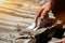 Closeup hands of laborer holding wood trowel working at construction site