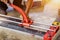 Closeup hands of laborer using cutting tile machine at construction site