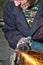 Closeup of Hands of Male Fitter in Protective Gloves and Uniform With Gringer Tool For Metal Work With Bunch of Sparks in Workshop