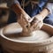 closeup of hands molding pot on spinning wheel