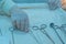 Closeup, the hands of a nurses hand, an assistant surgeon takes a surgical instrument from a sterile table. In a sterile operating