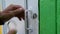 Closeup of hands opening a padlock