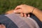 Closeup of the hands of a person laying on the green grass in the sun