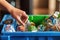 Closeup Of Hands Placing Recyclable Items Into Recycling Bin. Generative AI