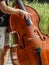 Closeup of hands play on a double bass / contrabass outdoors