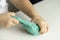 closeup hands of a preschooler child tearing turquoise mass for modeling