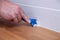 Closeup hands of professional plumber worker applying white sealant, joint compound, caulk to joint of wooden table top