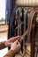 Closeup hands of professional tanner choosing belt buckle on wooden table at leather workshop