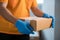 Closeup hands in rubber gloves handle cardboard boxes for fast online shopping delivery