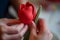 closeup of hands shaping a red fondant tulip