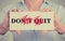 Closeup hands sign don\'t quit do it message