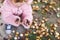 Closeup of hands of toddler girl picking chestnuts in a park on autumn day. Child having fun with searching chestnut and