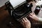 Closeup of hands typing retro vintage typewriter