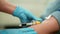 Closeup hands of unrecognizable female nurse in gloves drawing sample of blood from vein on male patient arm for testing