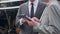 Closeup hands young engineer man and woman in suit checking train with tablet in station.