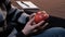 Closeup of the hands of a young man in a gray sweater. The guy is considering a ripe red apple. Student, artist or writer. Noteboo