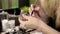 closeup on hands of young woman holding brush and jar of shadows at beauty salon