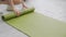 Closeup hands of young woman rolling with mat yoga on floor for preparation meditation and exercise for recreation.