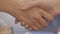 Closeup of handshake on background of office. Good business deal secured partnership with handshake. Two coworkers