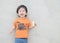 Closeup happy asian kid with crispy corn snack in his hand on marble stone wall textured background with copy space